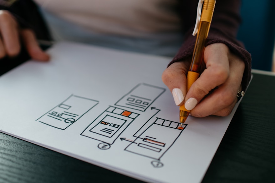 A hand sketching interface wireframes on paper